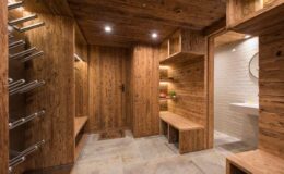 Modern wooden sauna interior featuring warm wood paneling, built-in benches, and ambient lighting, designed for relaxation and wellness.