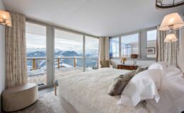 Luxurious mountain view bedroom featuring large windows, elegant decor, and a cozy atmosphere, ideal for a relaxing getaway in a scenic location.