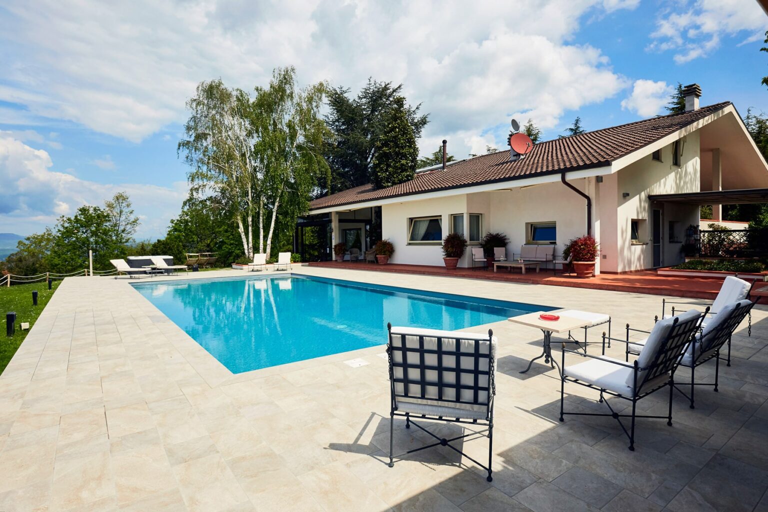 Modern villa with a swimming pool, surrounded by greenery, featuring outdoor seating and a sunny terrace. Ideal for relaxation and leisure activities. | Only on SopranoVillas