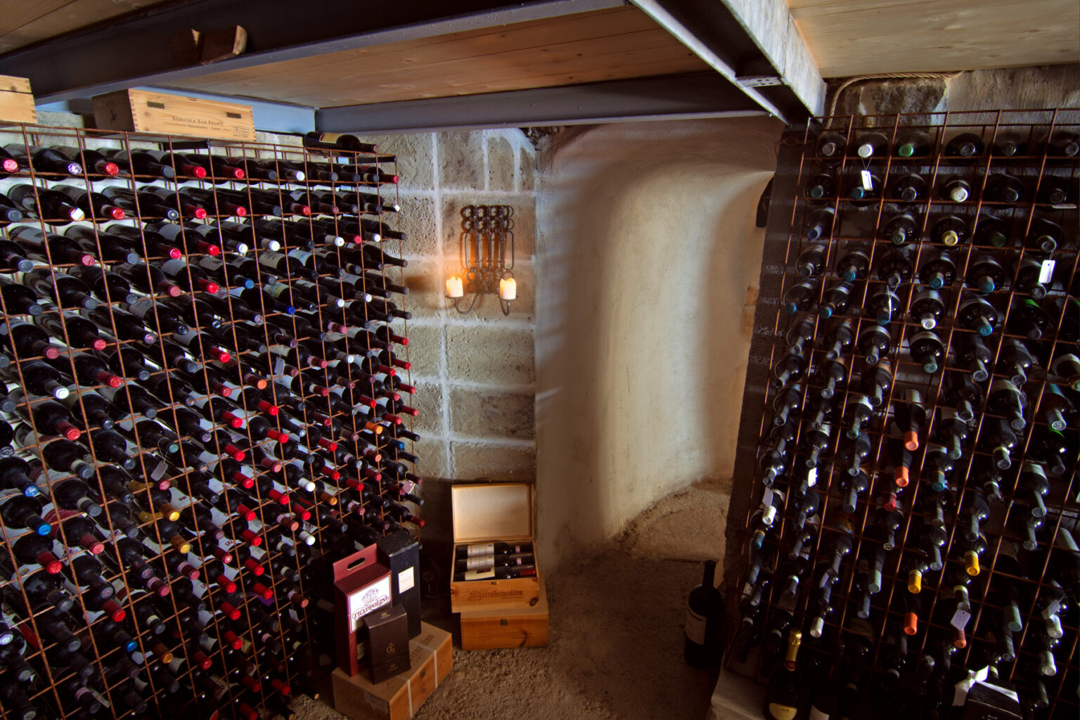 Wine cellar featuring organized racks filled with various bottles of wine, illuminated by soft lighting, creating a warm and inviting atmosphere. | Only on SopranoVillas