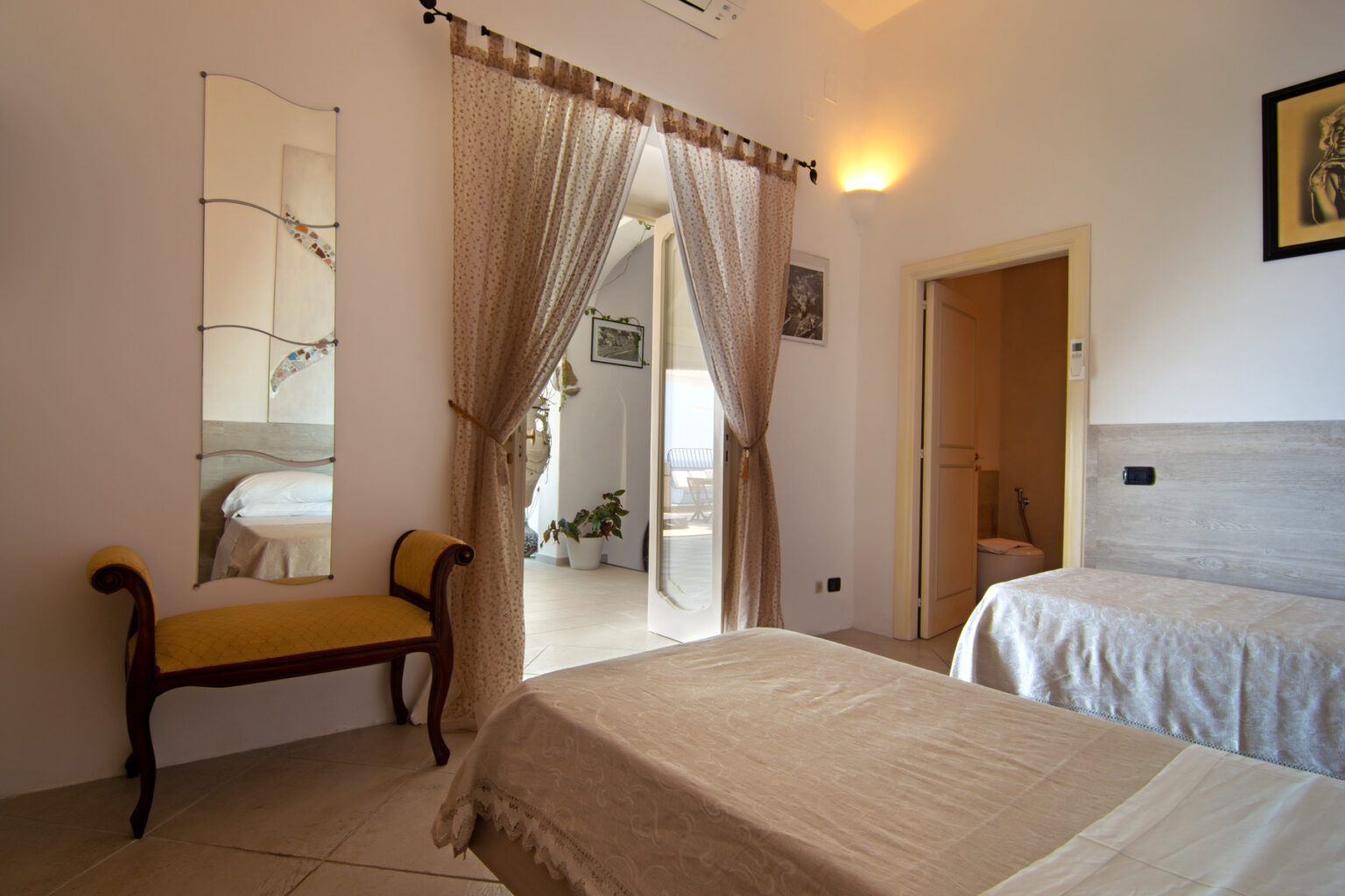 Cozy bedroom featuring two twin beds, a stylish mirror, and elegant decor, with natural light illuminating the space. | Only on SopranoVillas