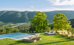 Modern outdoor living space featuring a luxurious infinity pool, lounge chairs, and lush greenery, with stunning mountain views in the background. Perfect for relaxation and entertainment.
