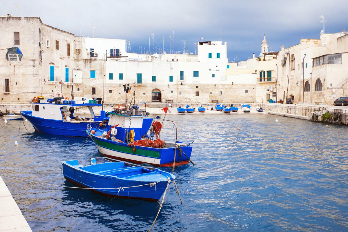 Blue fishing boats in the old harbour of Monopoli
