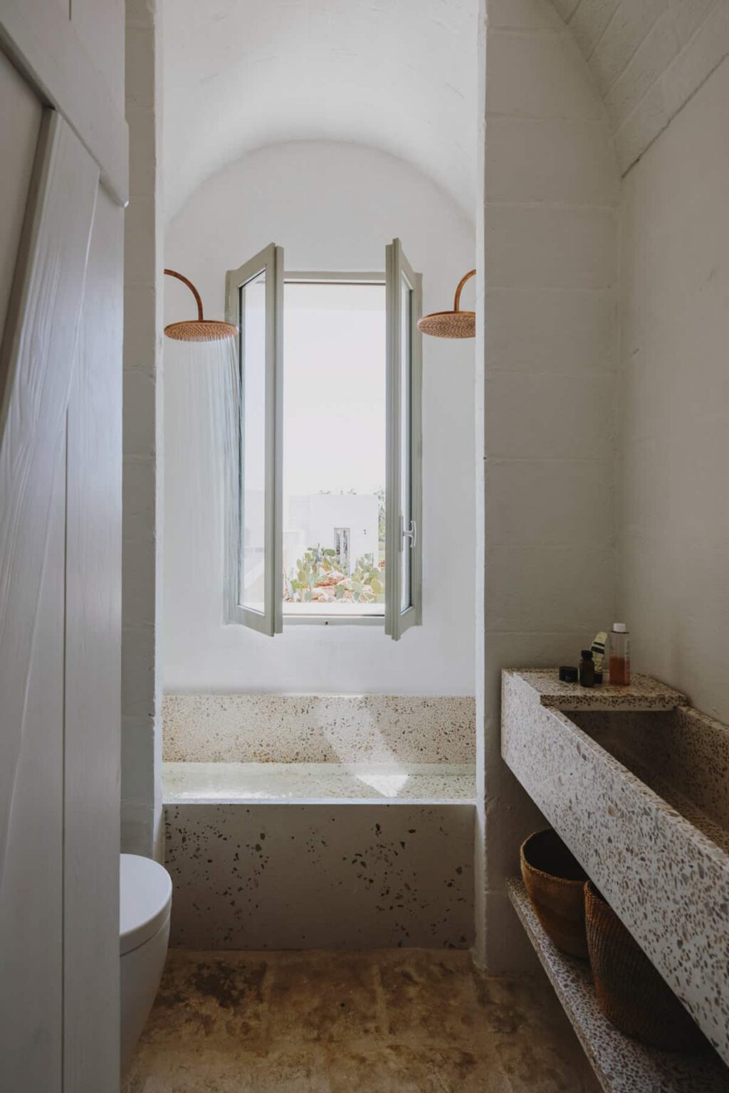 Bright bathroom with open window offering a scenic view, featuring a stone sink and modern light fixtures. | Only on SopranoVillas