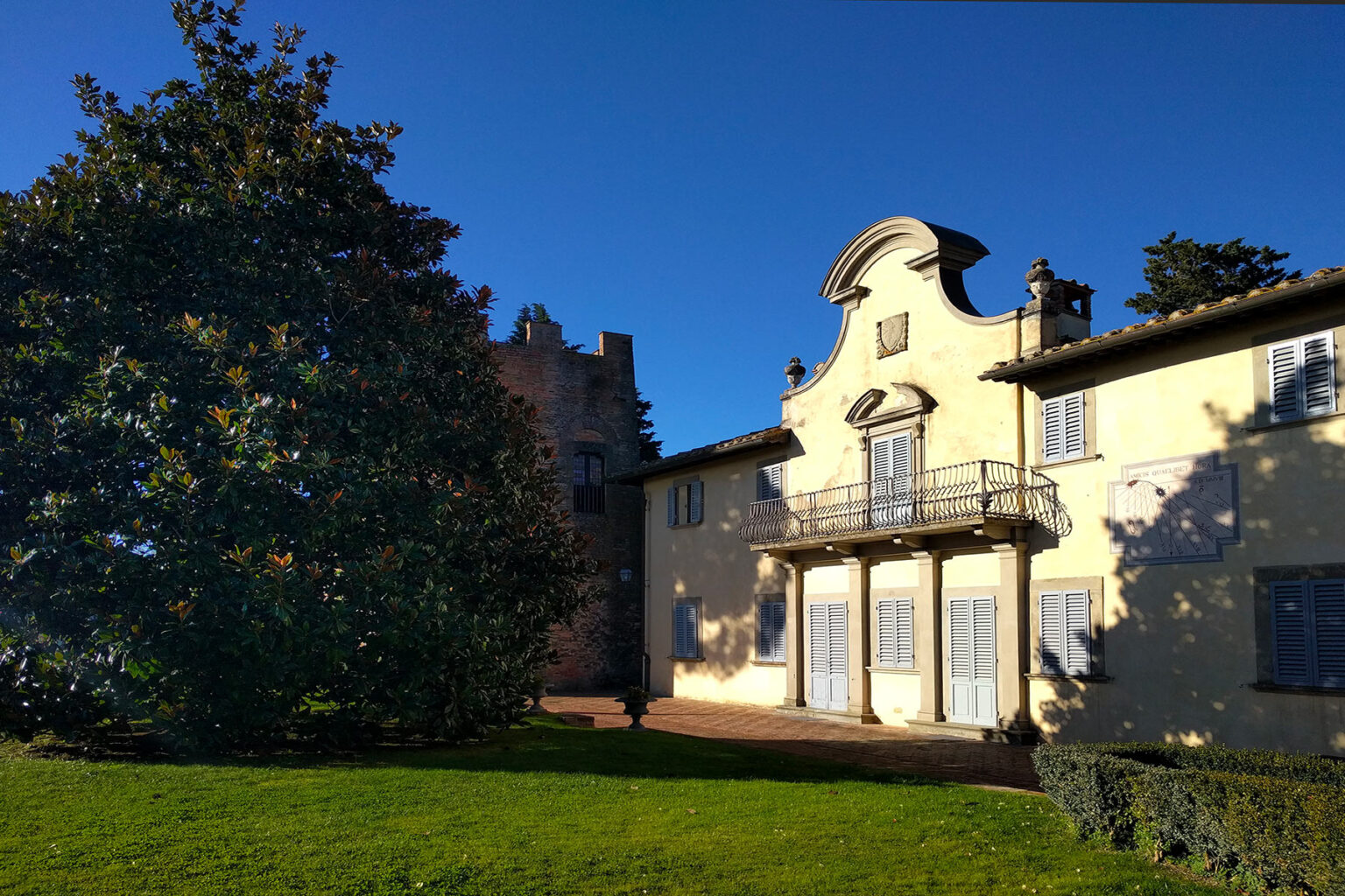 Historic villa with a yellow facade and decorative architecture, surrounded by lush greenery and a clear blue sky. Ideal for showcasing architectural beauty and landscape design. | Only on SopranoVillas