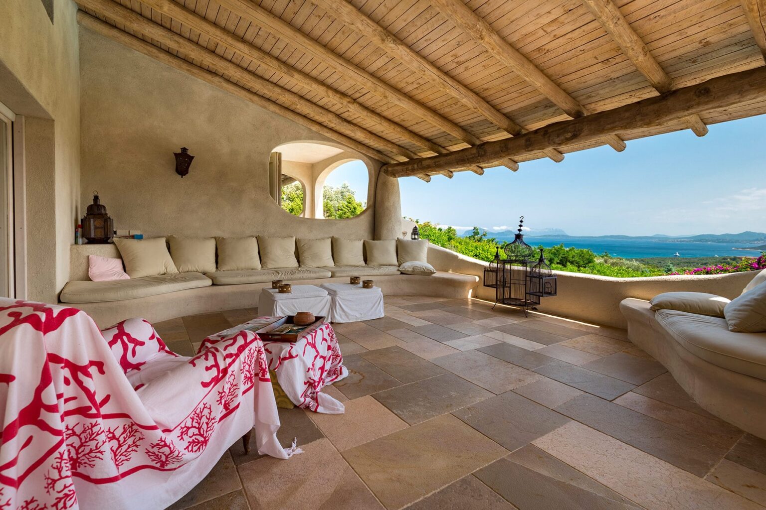 Spacious outdoor terrace with comfortable seating, decorative blankets, and stunning mountain views under a wooden pergola. | Only on SopranoVillas