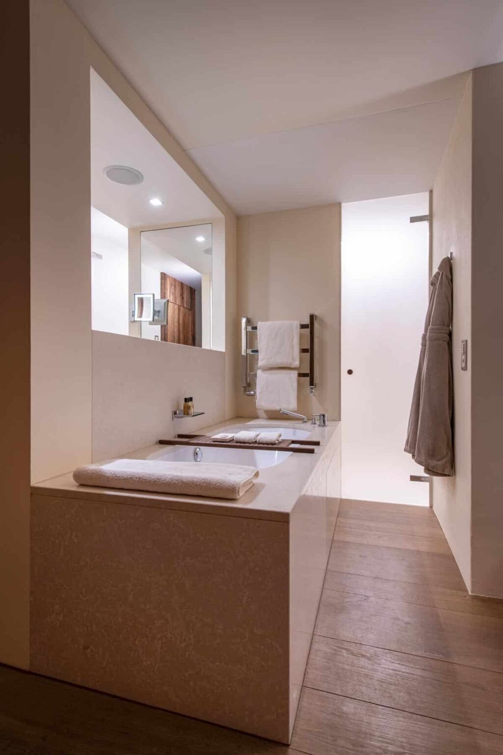 Modern bathroom interior featuring a sleek dual sink vanity, large mirrors, neatly arranged towels, and a minimalist design. Natural light enhances the spacious feel, showcasing contemporary fixtures and a clean aesthetic. | Only on SopranoVillas