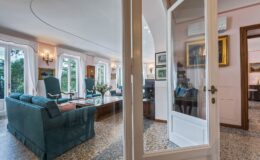 Spacious living room with elegant furniture, large windows providing natural light, and decorative artwork, showcasing a welcoming and comfortable ambiance.