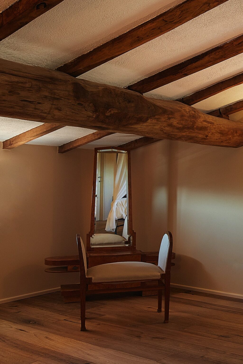 Interior view of a cozy room featuring a tall, ornate mirror, a wooden beam ceiling, and soft lighting, creating a warm and inviting atmosphere. | Only on SopranoVillas