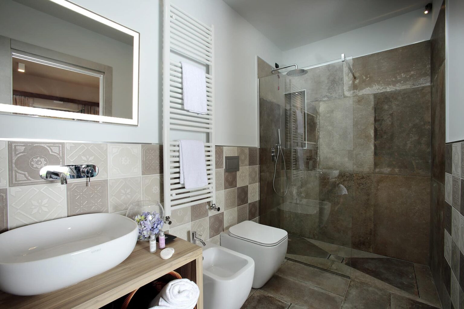 Modern bathroom design featuring a glass shower, large vanity with a round sink, and stylish tiled walls. The space is bright and functional, ideal for contemporary home interiors. | Only on SopranoVillas