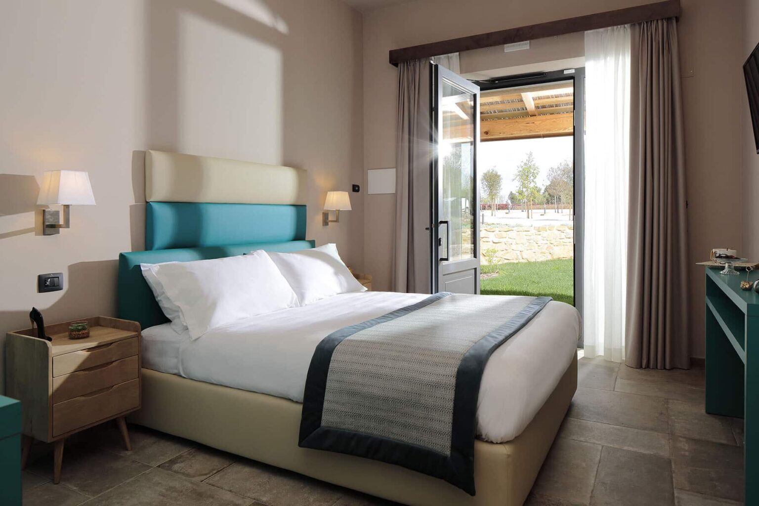 Cozy hotel bedroom featuring a comfortable king-size bed, modern decor, and large windows opening to a scenic outdoor view. Ideal for relaxation and luxury stays. | Only on SopranoVillas