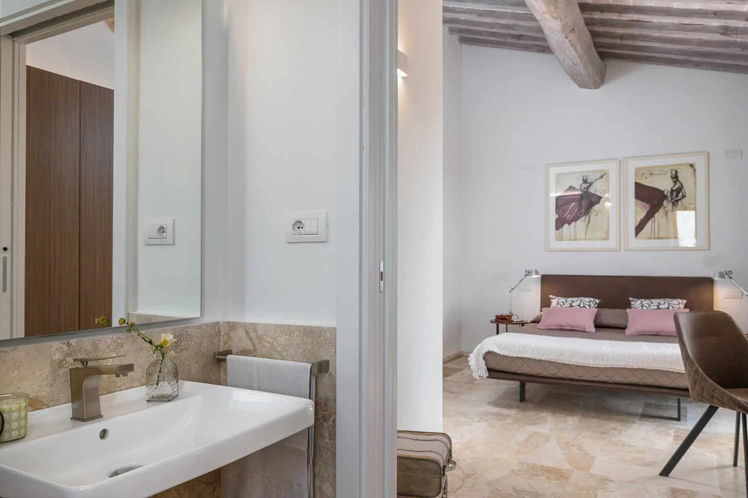 Modern bathroom and bedroom interior featuring a stylish sink, neutral color palette, and contemporary decor with artwork on the walls. | Only on SopranoVillas