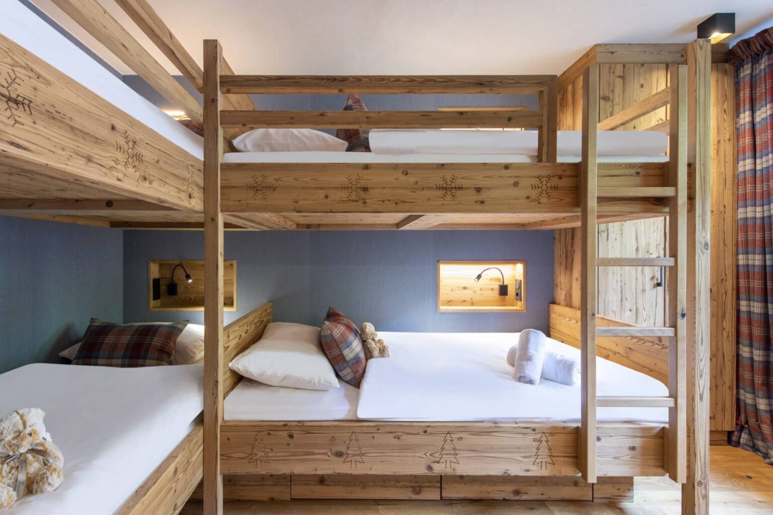 Cozy multi-level bunk bed room featuring rustic wooden furniture, comfortable bedding, and decorative pillows, ideal for group accommodations or family stays. | Only on SopranoVillas
