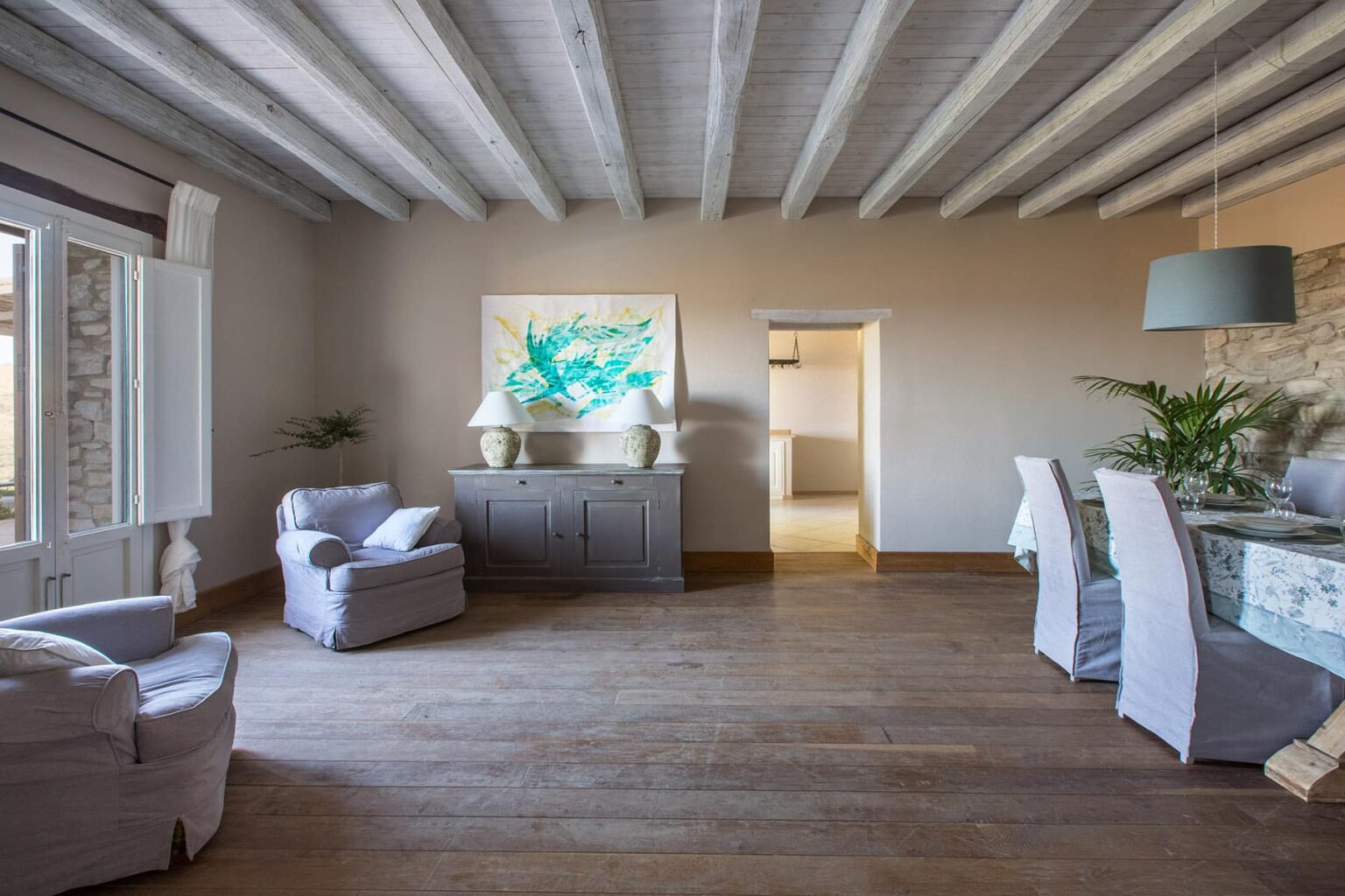 Spacious living room featuring wooden beams, stylish furniture, and natural light, with a serene color palette and decorative artwork. Ideal for interior design inspiration. | Only on SopranoVillas