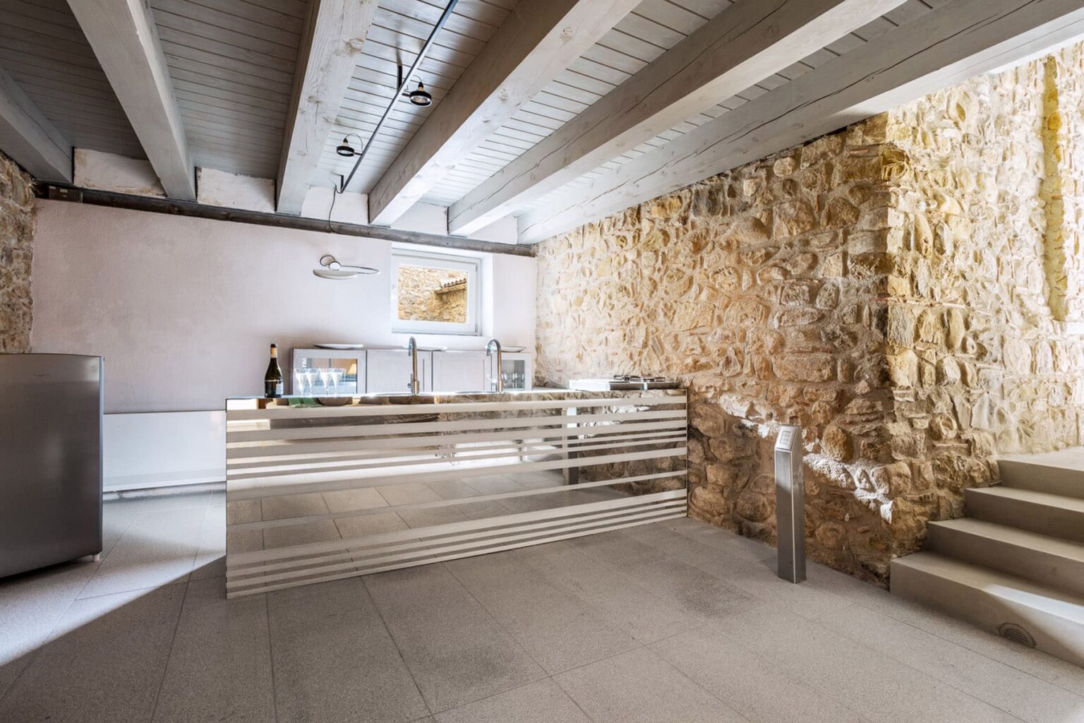 Modern interior of a stylish reception area featuring a sleek glass counter, stone wall accents, and contemporary lighting, ideal for hospitality or office environments. | Only on SopranoVillas