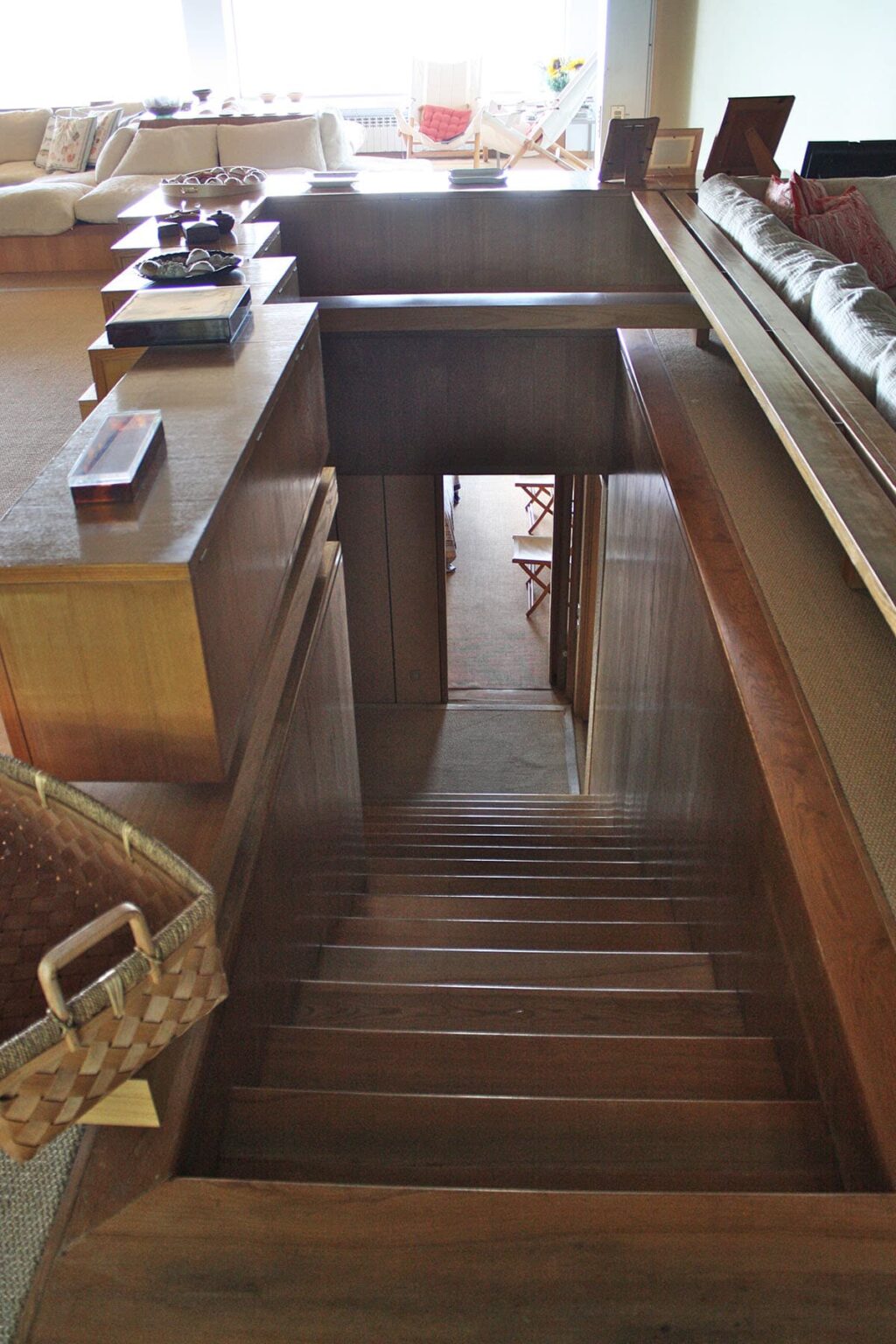 Interior view of a wooden staircase leading down to a room with wooden furniture, showcasing a warm and inviting atmosphere. | Only on SopranoVillas