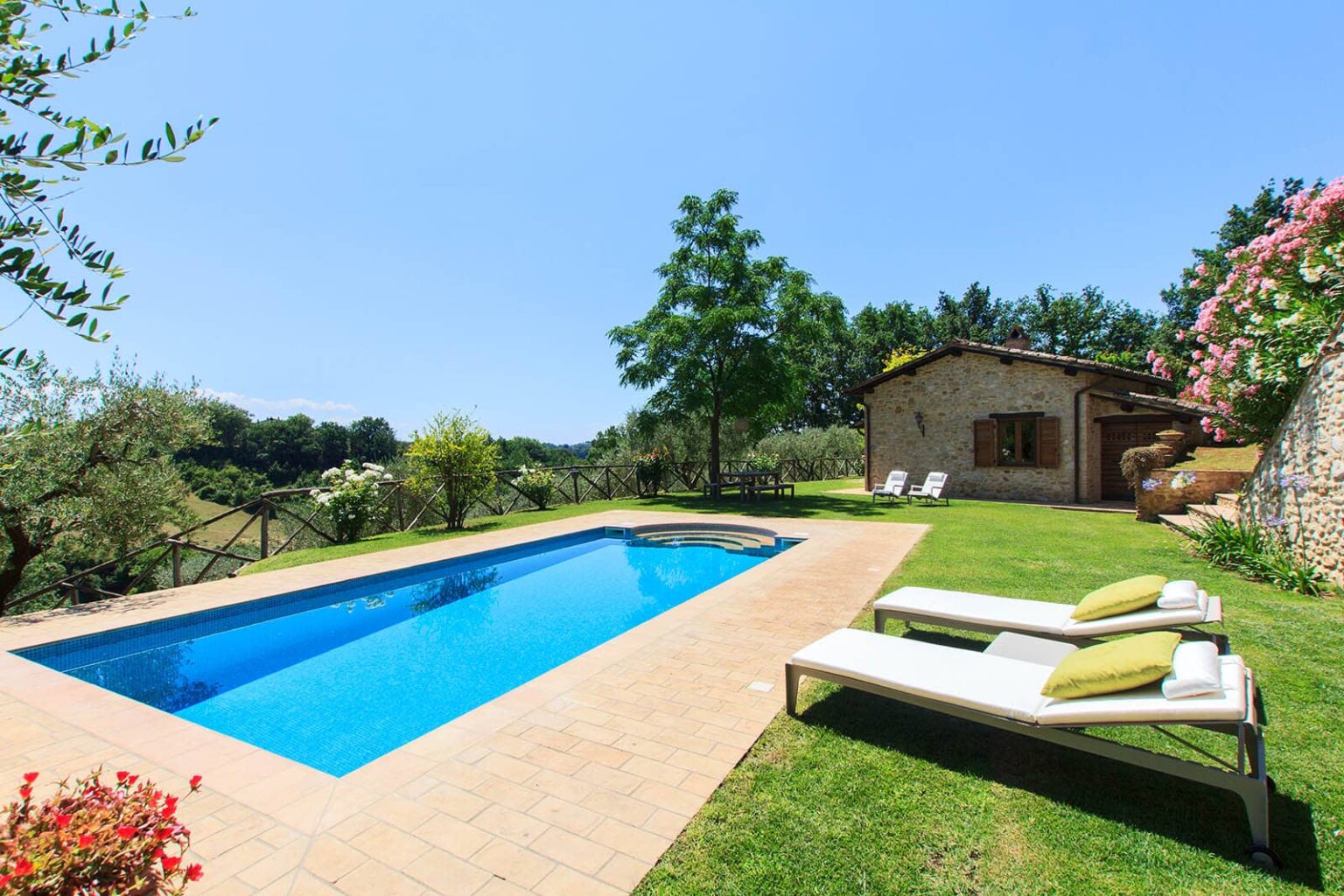 Luxurious outdoor pool surrounded by lush greenery and a cozy cottage in a tranquil setting, perfect for relaxation and leisure. | Only on SopranoVillas