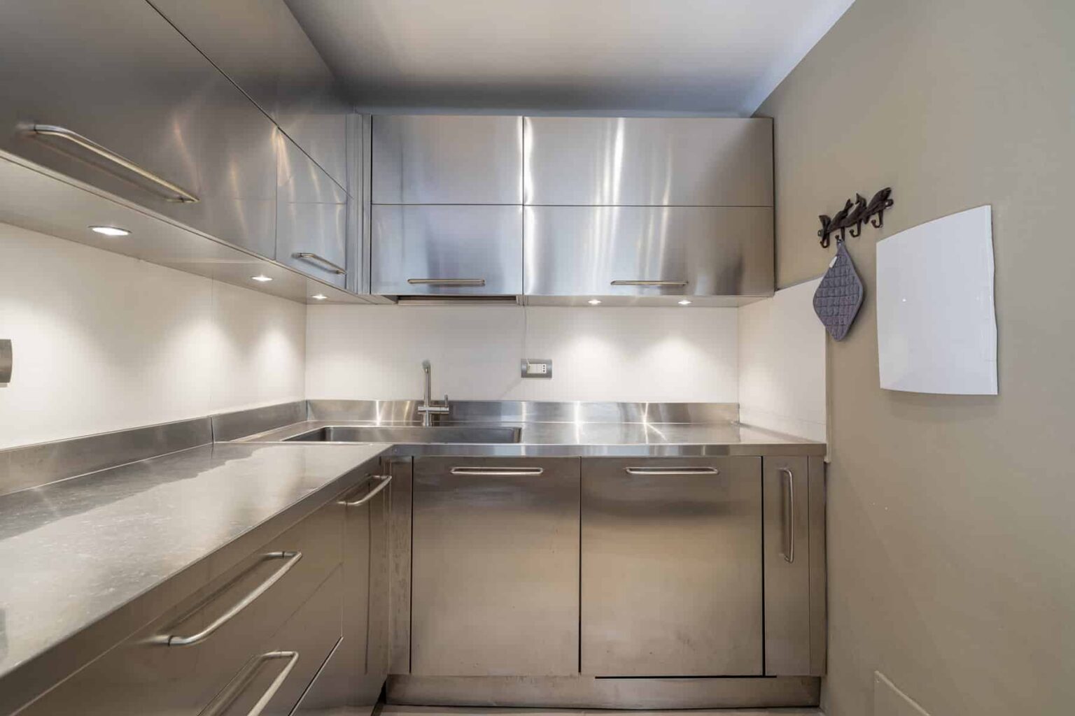 Modern kitchen with stainless steel appliances, sleek cabinetry, and bright lighting, featuring a minimalist design and functional layout. | Only on SopranoVillas