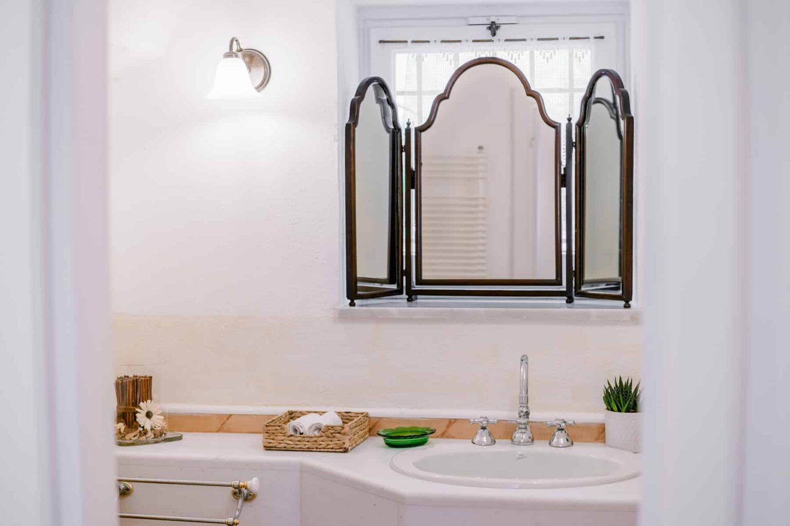 Elegant bathroom interior featuring a freestanding bathtub, a stylish three-panel mirror, and modern fixtures. Natural light illuminates the space, enhancing the serene atmosphere. | Only on SopranoVillas