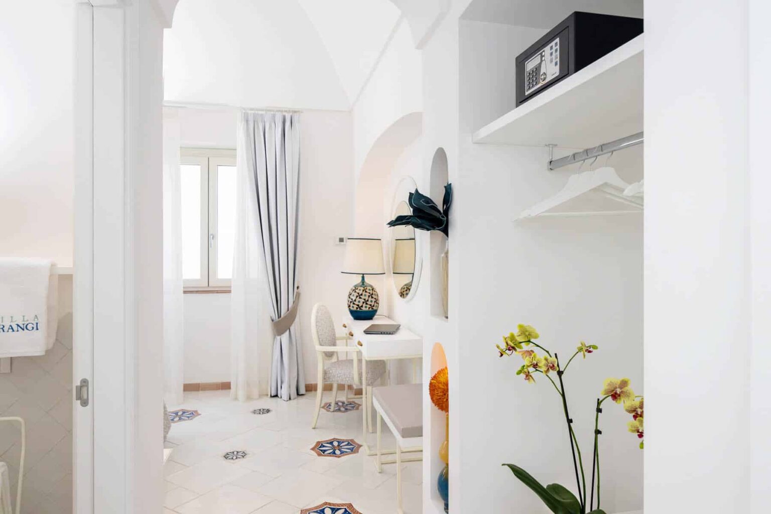 Bright and modern interior of a stylish room featuring a small dining area, decorative lamp, and a touch of greenery, showcasing a minimalist design with white walls and elegant furnishings. | Only on SopranoVillas