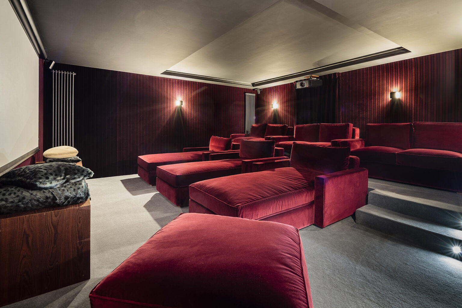 Home theater interior featuring plush red seating, a large projection screen, and ambient lighting for a cozy movie-watching experience. | Only on SopranoVillas