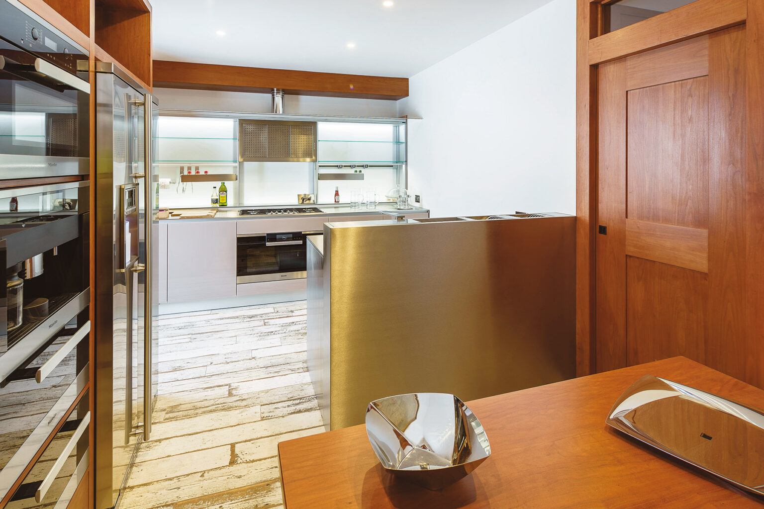 Modern kitchen interior featuring stainless steel appliances, wooden cabinetry, and a spacious layout with natural light. The image showcases a sleek design with an emphasis on functionality and style. | Only on SopranoVillas