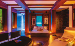 Modern spa interior featuring a serene atmosphere with ambient lighting, a comfortable bed, and lounge chairs, designed for relaxation and wellness.