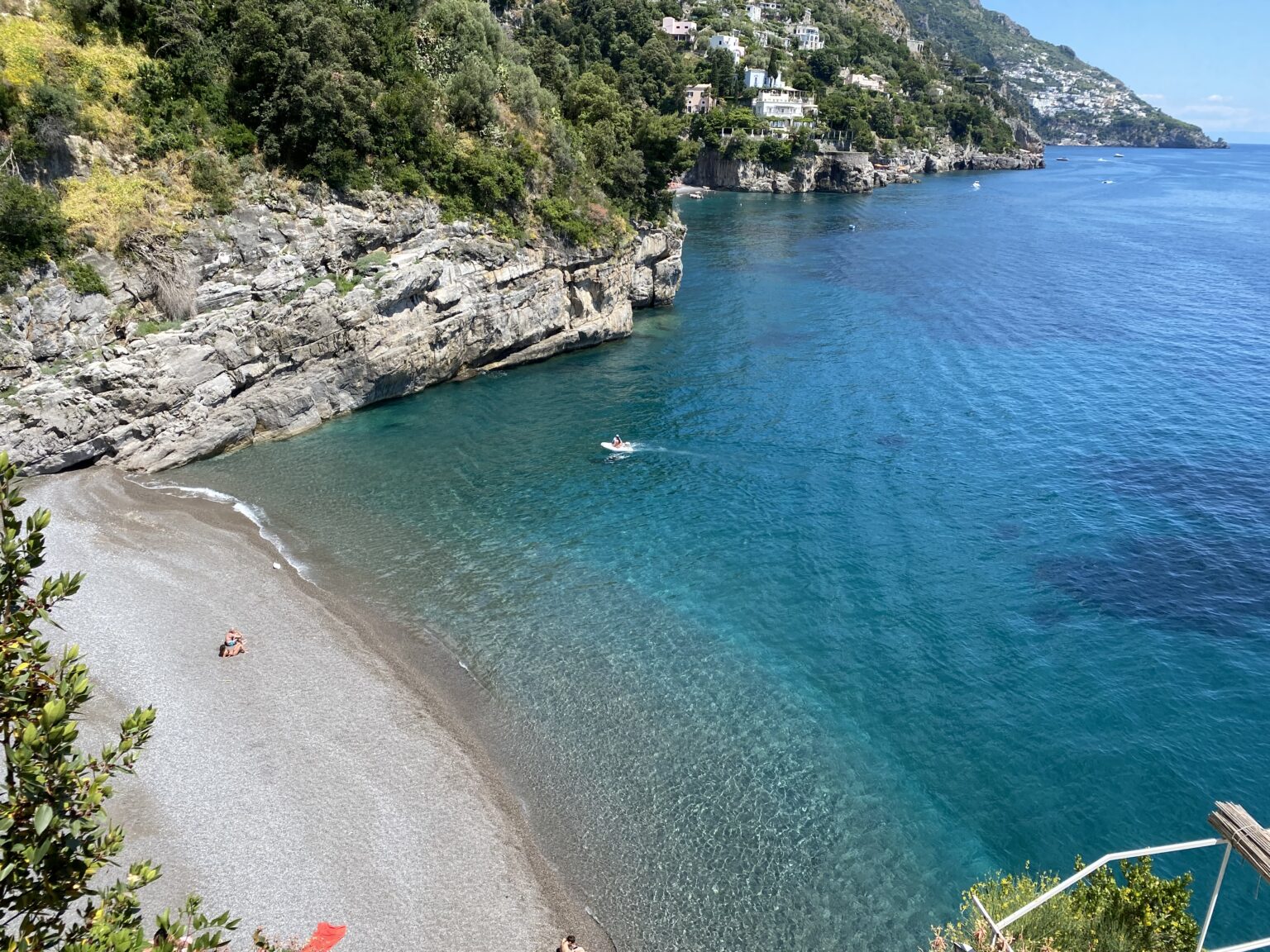 Scenic view of a secluded beach in Italy, showcasing crystal-clear turquoise waters and rocky cliffs, ideal for luxury villa rentals. | Only on SopranoVillas