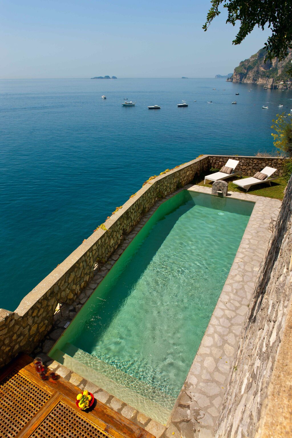Luxury villa with a private pool overlooking the serene waters of Italy, featuring sun loungers for relaxation and stunning views. Ideal for a premium vacation rental experience. | Only on SopranoVillas