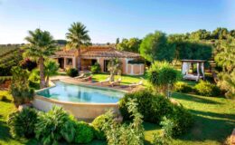 Luxurious villa with a swimming pool surrounded by lush greenery and palm trees, featuring a spacious outdoor area and scenic views. Ideal for relaxation and outdoor living.