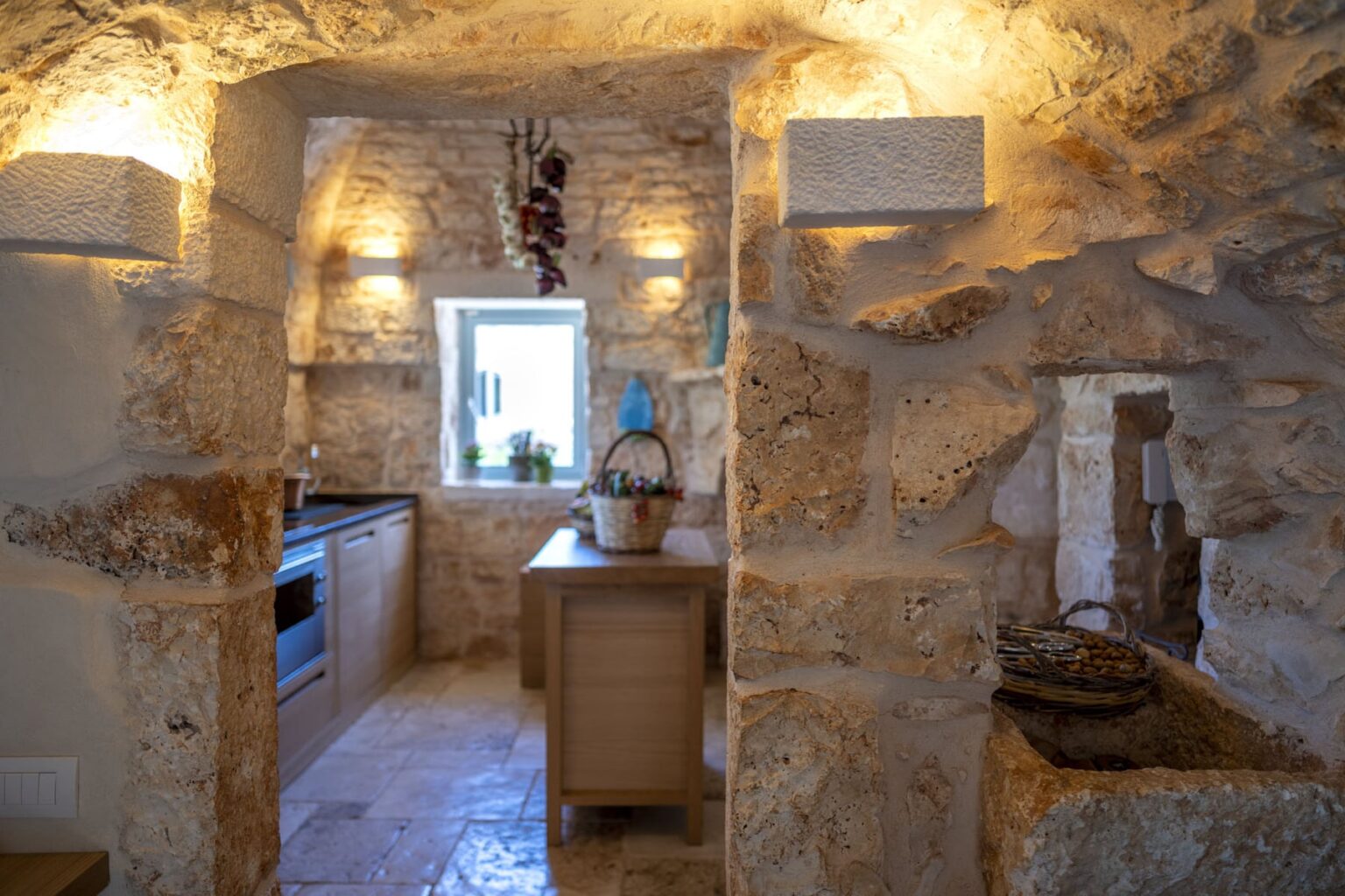 Rustic kitchen interior featuring natural stone walls, modern appliances, and warm lighting, creating a cozy atmosphere. | Only on SopranoVillas