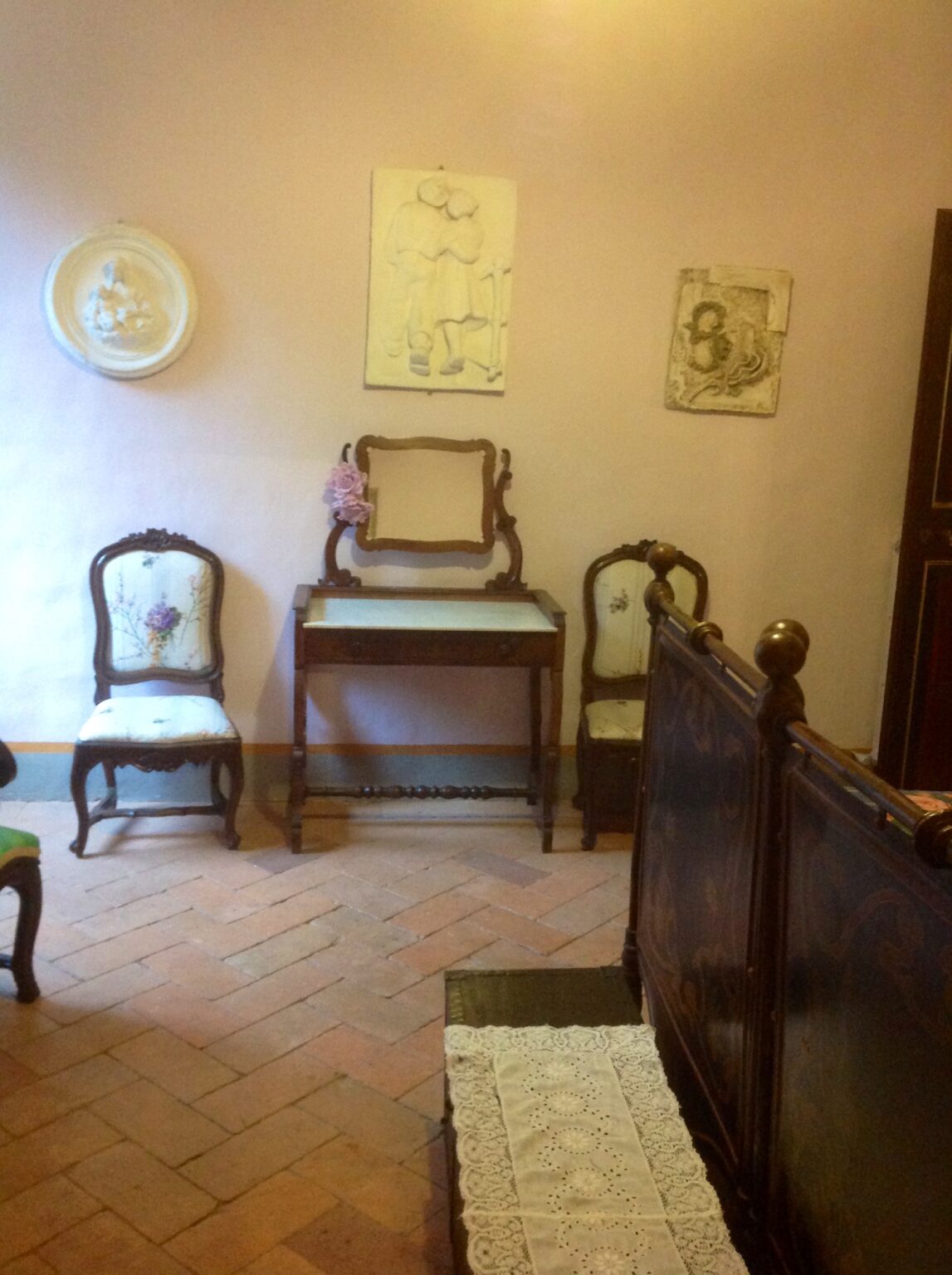 Vintage vanity table with a mirror and two ornate chairs in a softly lit room, featuring pastel wall decor and wooden flooring. Ideal for showcasing antique furniture aesthetics. | Only on SopranoVillas