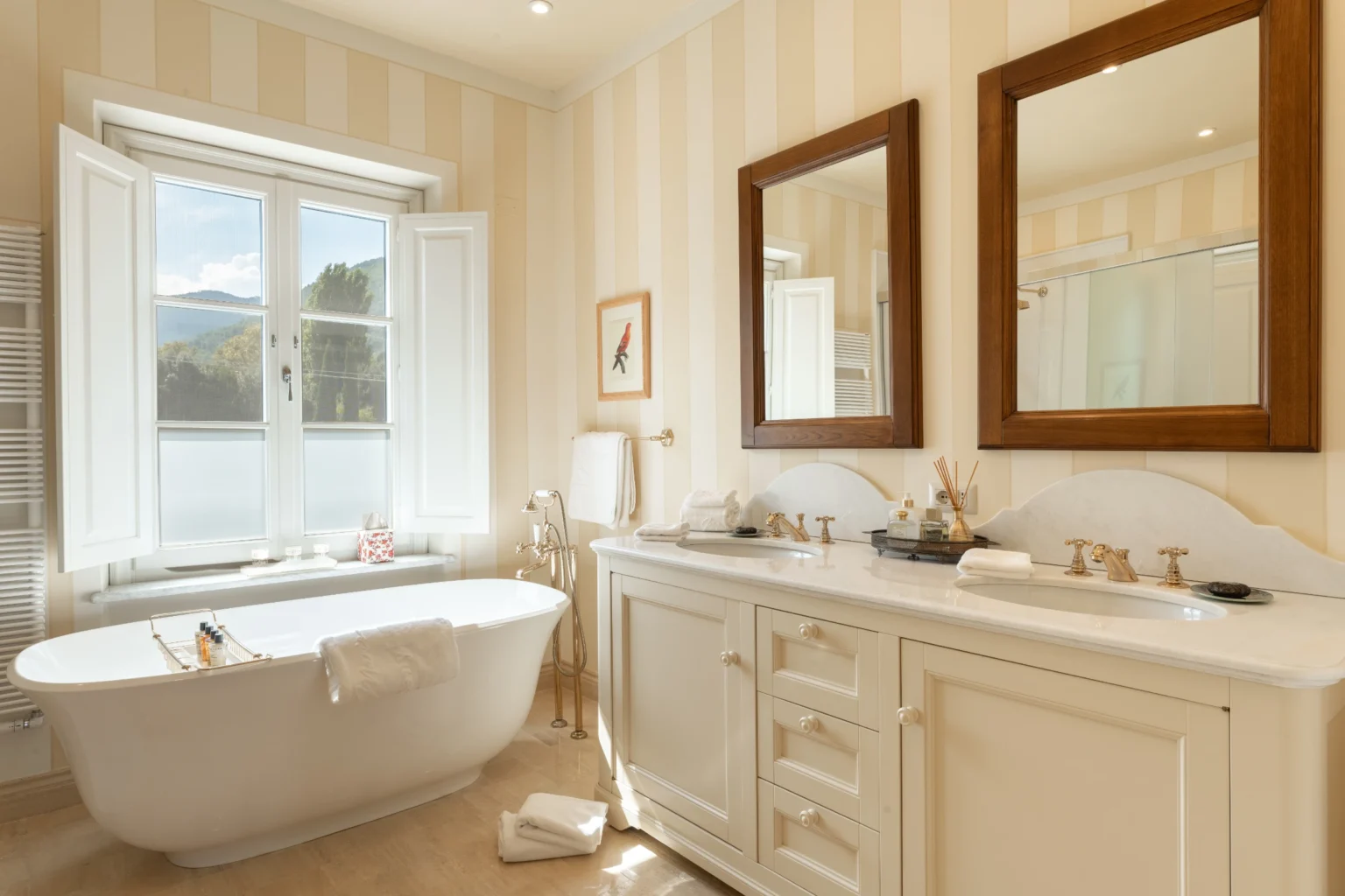 Luxurious bathroom in a rental villa in Italy featuring a freestanding bathtub, elegant decor, and natural light from large windows. Ideal for a relaxing getaway. | Only on SopranoVillas
