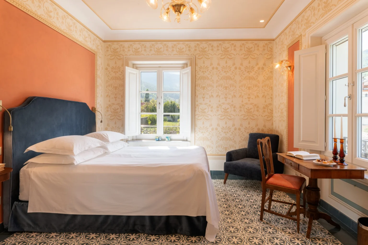 Luxury villa bedroom in Italy featuring an elegant design, large windows with scenic views, a comfortable bed, and stylish furnishings, perfect for a relaxing getaway. | Only on SopranoVillas