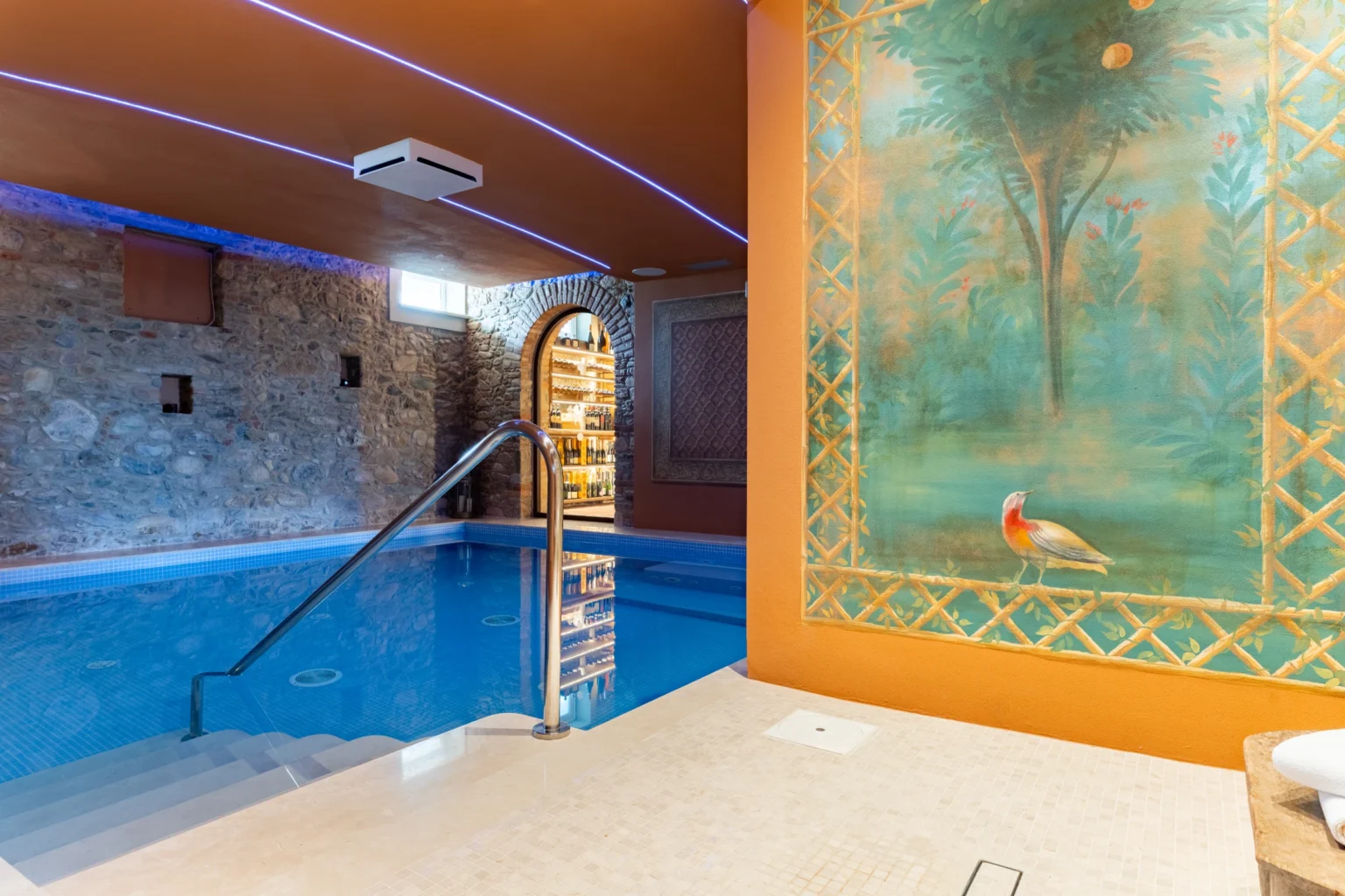 Luxury villa rental in Italy featuring an indoor swimming pool with elegant decor and soothing lighting, ideal for relaxation and wellness retreats. | Only on SopranoVillas
