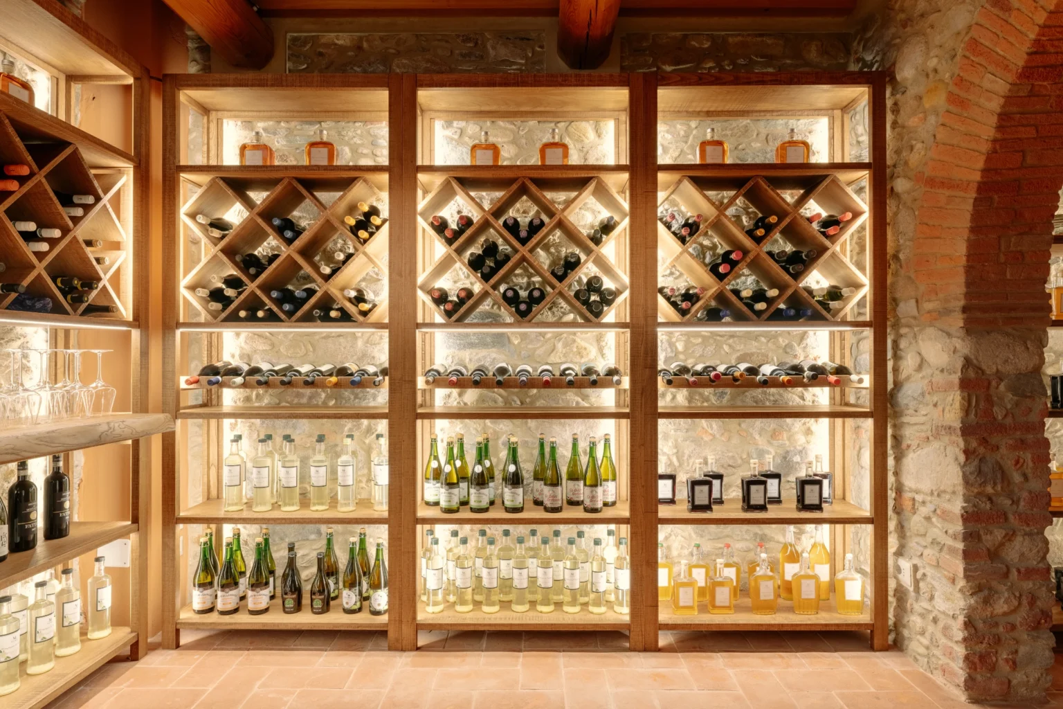 Luxurious wine cellar featuring elegantly arranged shelves with a variety of fine wines and spirits, ideal for enhancing the experience in upscale villas for rent in Italy. | Only on SopranoVillas