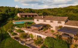 Aerial view of a charming stone villa surrounded by lush greenery, featuring a swimming pool, solar panels, and landscaped gardens, ideal for a serene getaway.