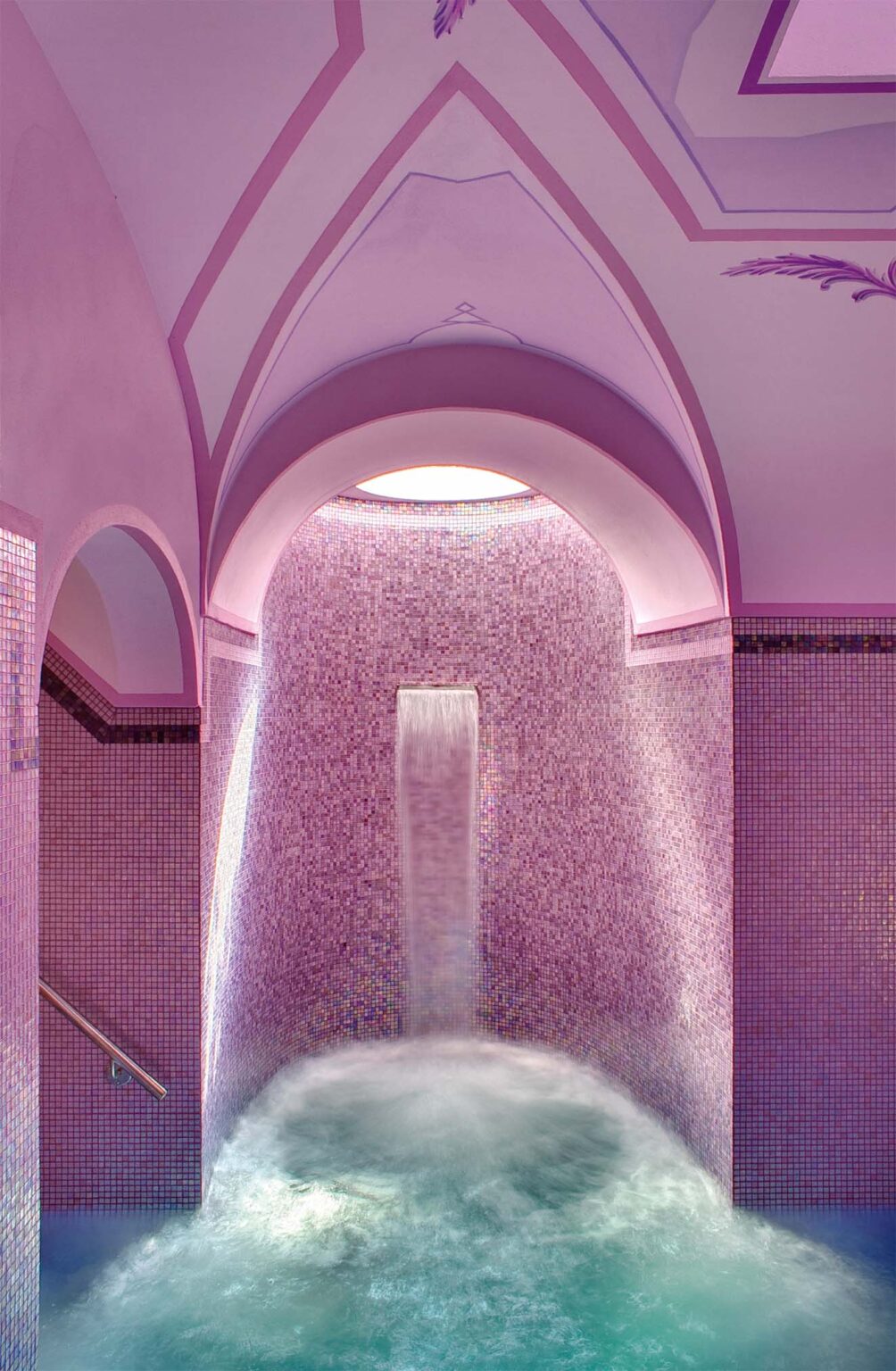 Serene spa interior featuring a cascading waterfall, purple tiled walls, and soft mist, creating a tranquil atmosphere for relaxation and rejuvenation. | Only on SopranoVillas