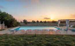 Serene outdoor swimming pool at sunset, surrounded by lush greenery and comfortable lounge chairs, perfect for relaxation and leisure.