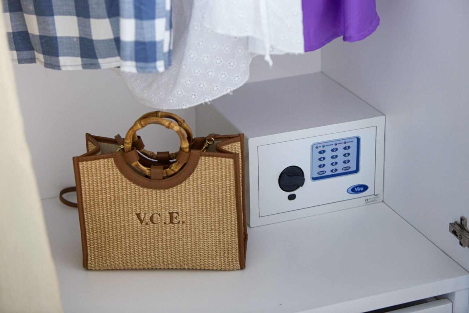 Stylish designer handbag placed next to a small safe inside a closet, showcasing a modern storage solution for valuables and fashion accessories. | Only on SopranoVillas