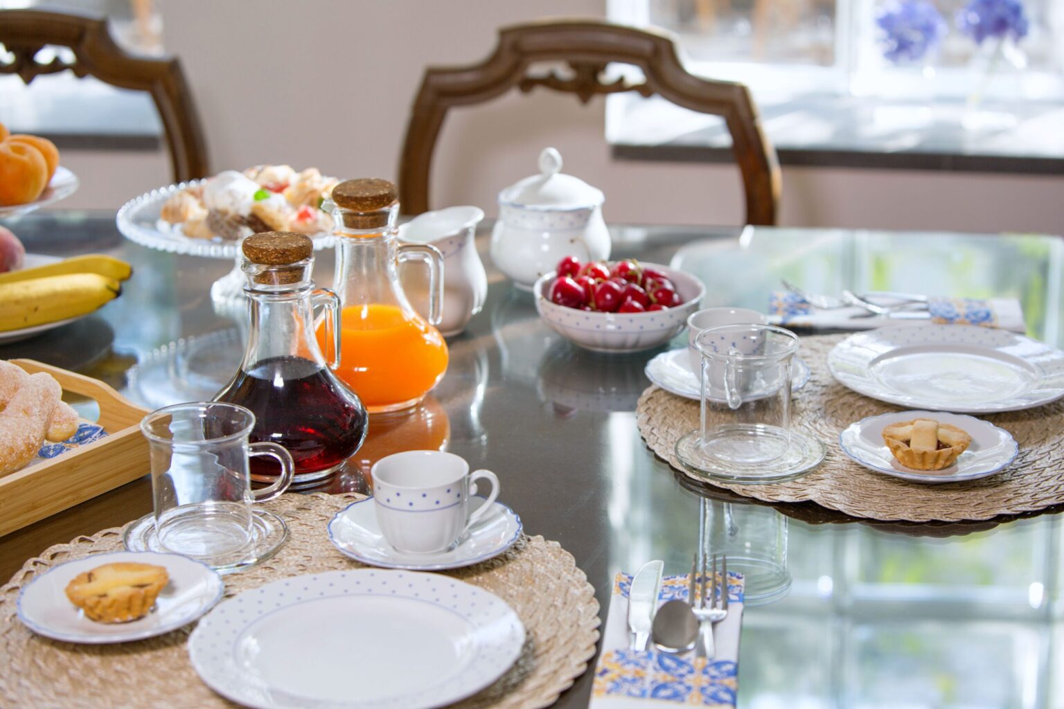 A beautifully arranged breakfast table featuring an assortment of pastries, fruit, and beverages, with elegant tableware and a cozy dining atmosphere. | Only on SopranoVillas