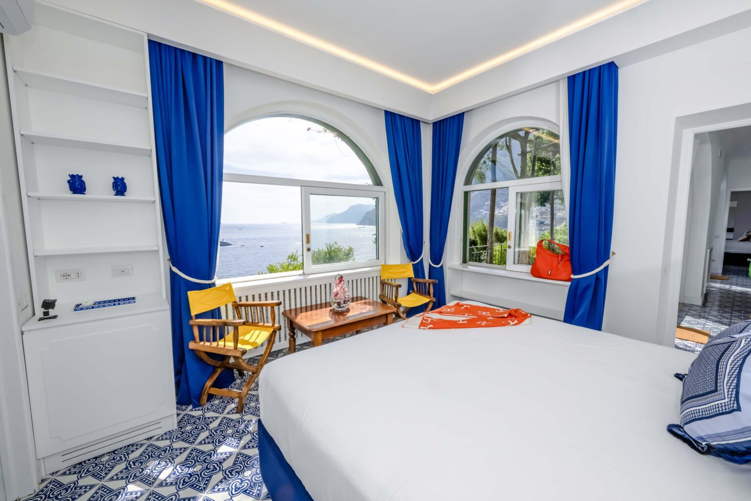Luxurious bedroom in a villa for rent in Italy, featuring elegant decor, large windows with scenic views, and stylish furnishings, ideal for a relaxing getaway. | Only on SopranoVillas