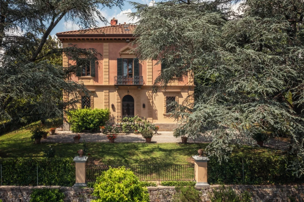 Elegant historic villa surrounded by lush greenery and well-maintained gardens, featuring classic architecture and a charming entrance. | Only on SopranoVillas