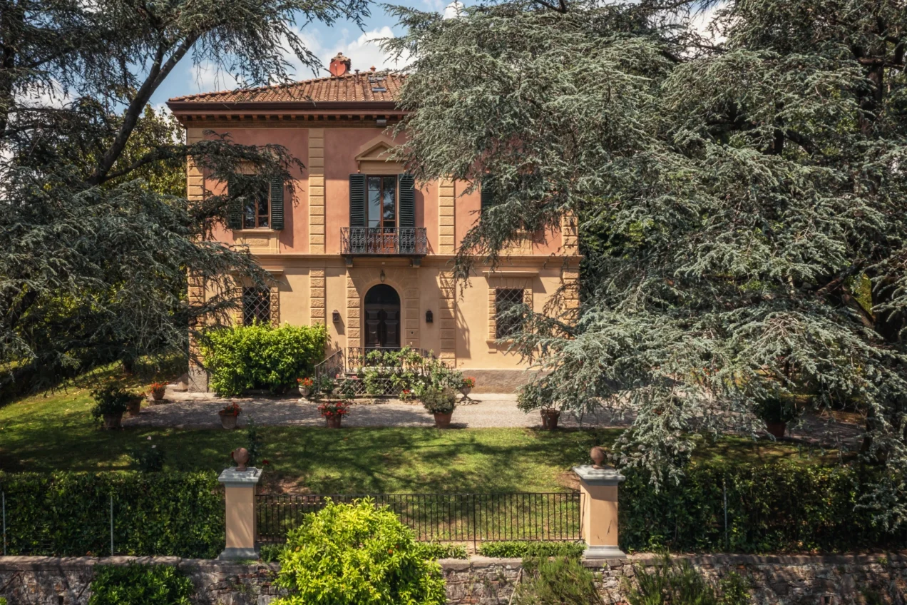 Elegant historic villa surrounded by lush greenery and well-maintained gardens, featuring classic architecture and a charming entrance. | Only on SopranoVillas