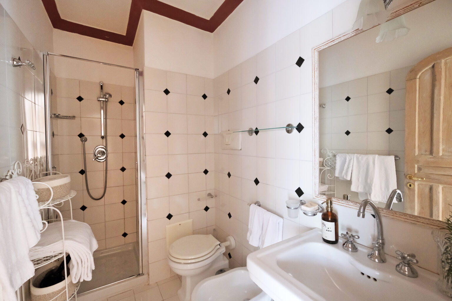 Modern bathroom design featuring a glass shower, elegant fixtures, and tasteful tile work. The space includes a bathtub, toilet, and a large mirror, creating a bright and inviting atmosphere. | Only on SopranoVillas
