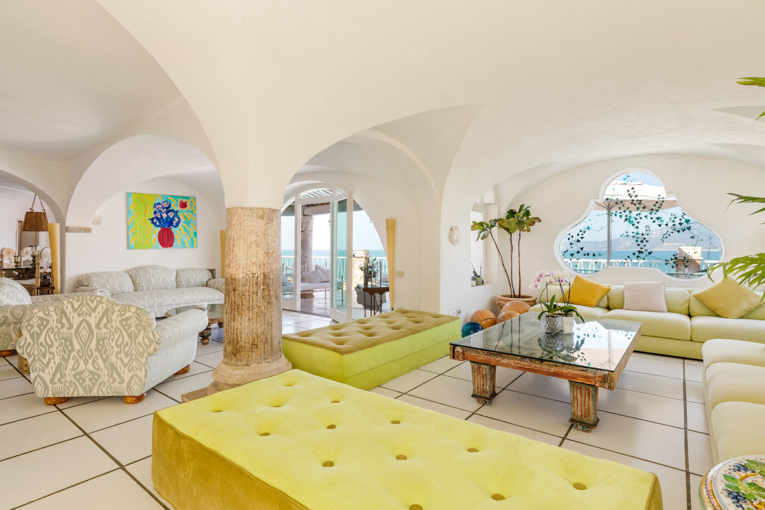 Spacious and bright living room featuring arched ceilings, modern furniture, and colorful decor, with large windows offering scenic views and natural light. | Only on SopranoVillas