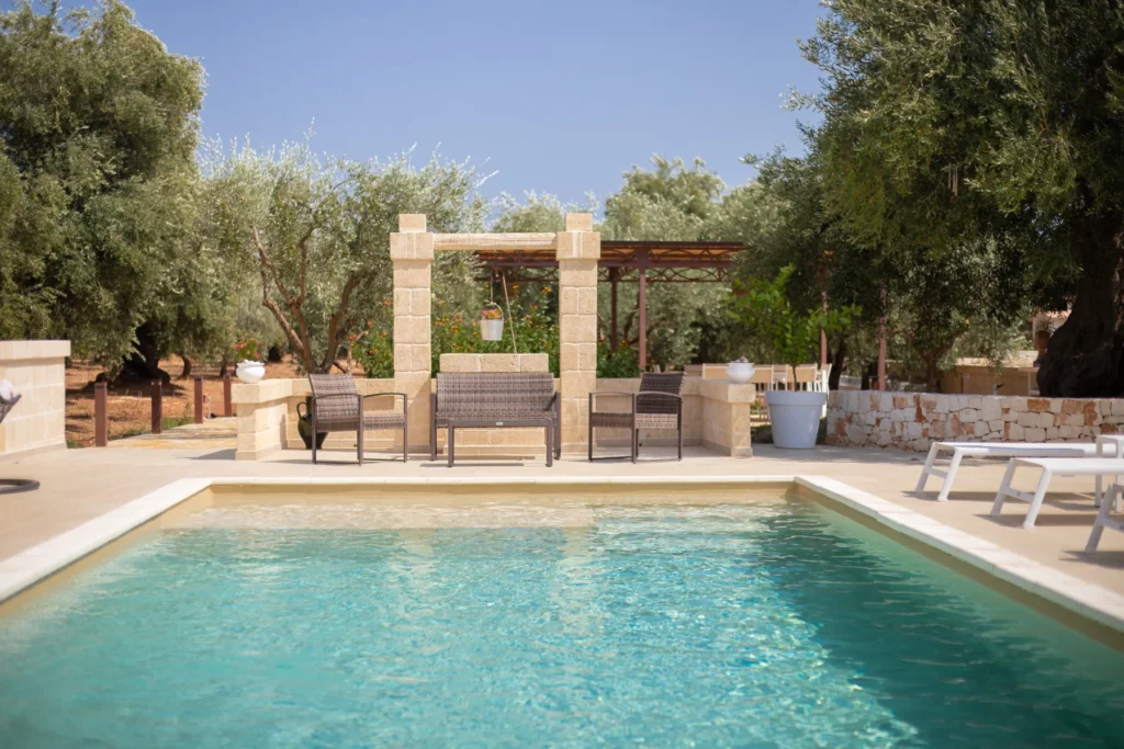Luxury villa with a swimming pool surrounded by olive trees, featuring outdoor seating and a serene landscape, perfect for relaxation and leisure. | Only on SopranoVillas