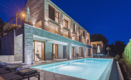 Modern villa with a swimming pool at night, featuring elegant architecture and ambient lighting, surrounded by lush greenery.