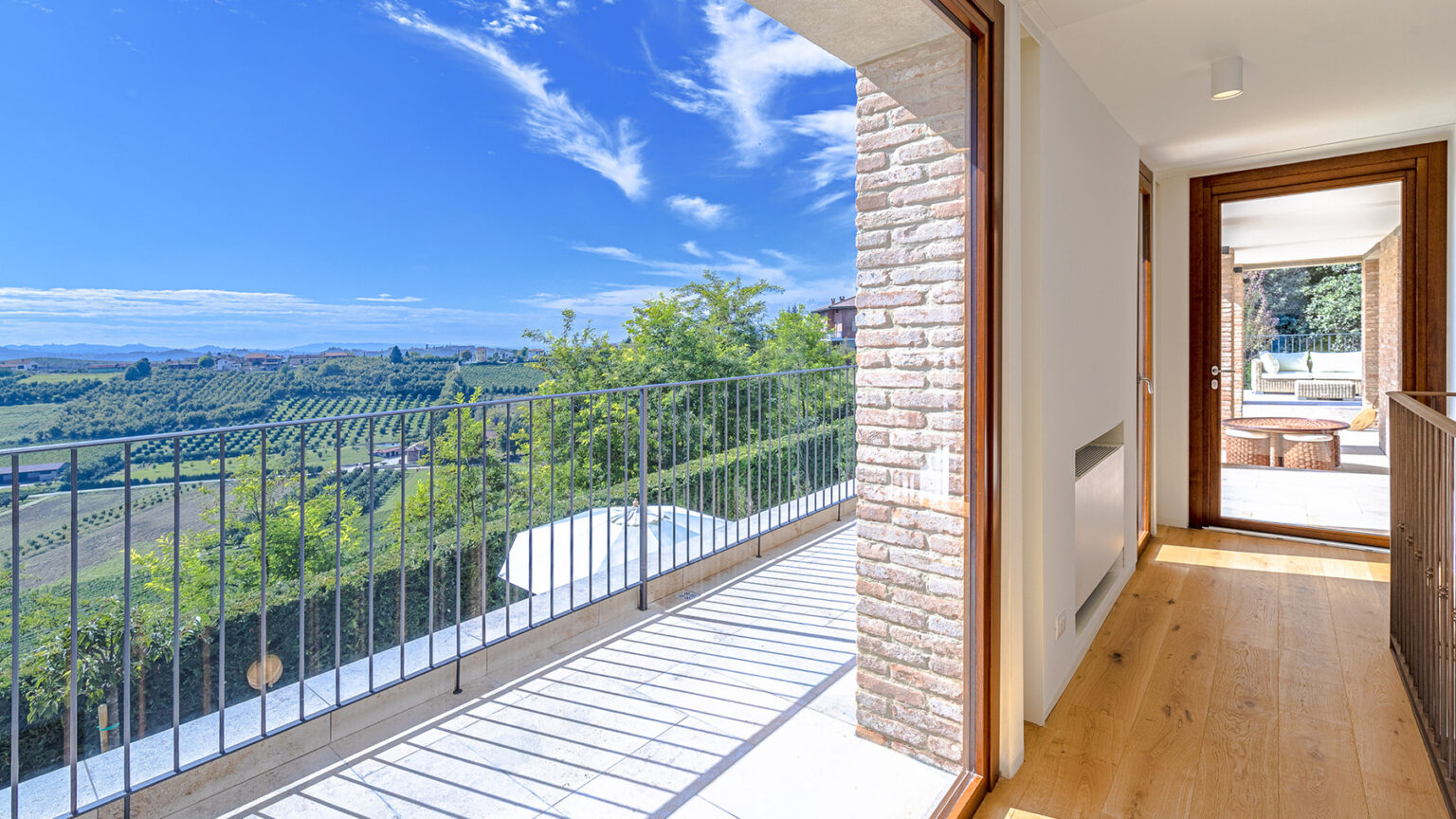 Modern interior with large windows showcasing a stunning landscape view, featuring wooden flooring and a balcony. Ideal for showcasing real estate or interior design. | Only on SopranoVillas