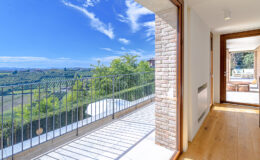 Modern interior with large windows showcasing a stunning landscape view, featuring wooden flooring and a balcony. Ideal for showcasing real estate or interior design.
